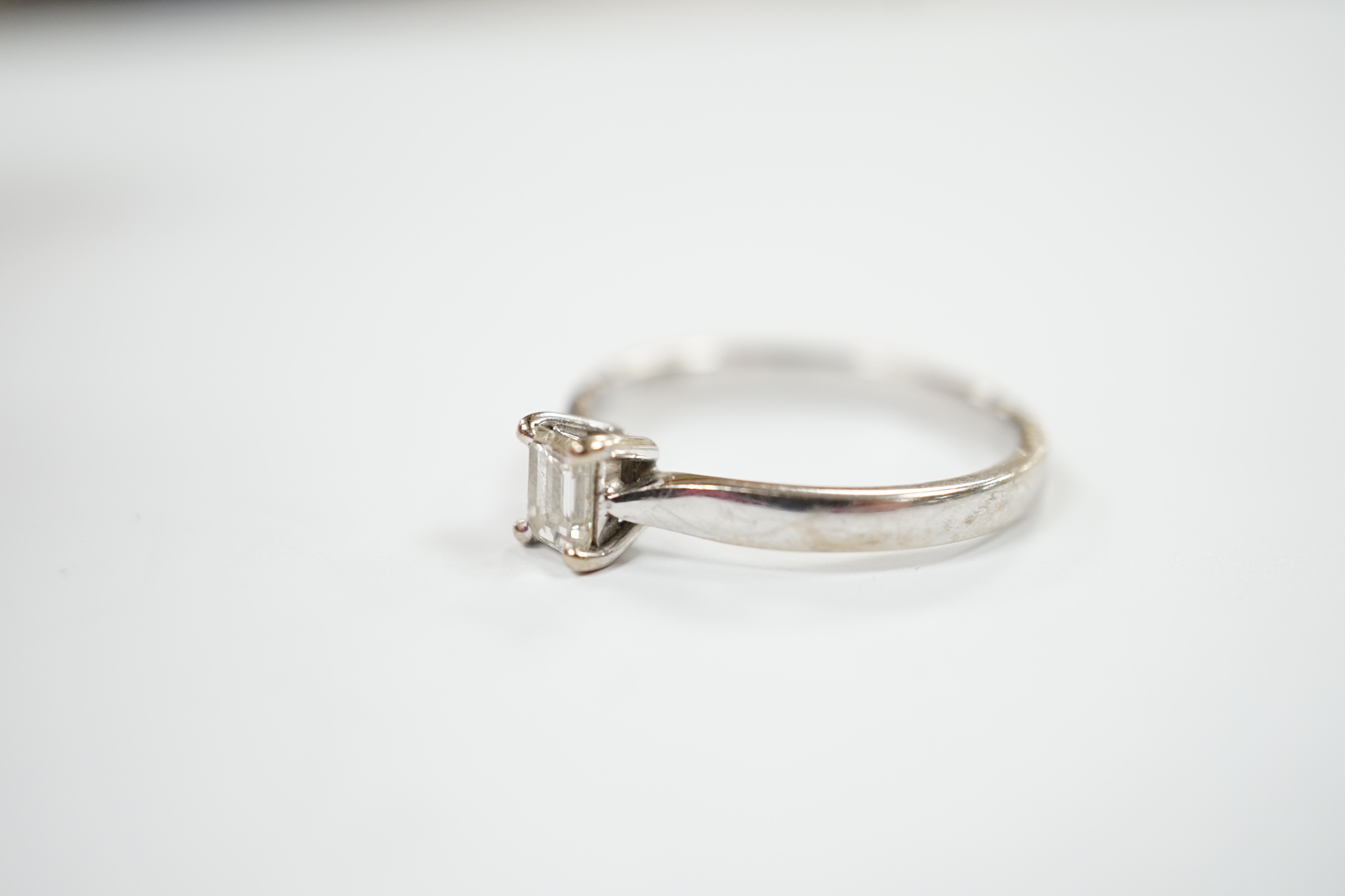 A modern 18ct white gold and solitaire emerald cut diamond set ring, size Q, gross weight 3.4 grams.
